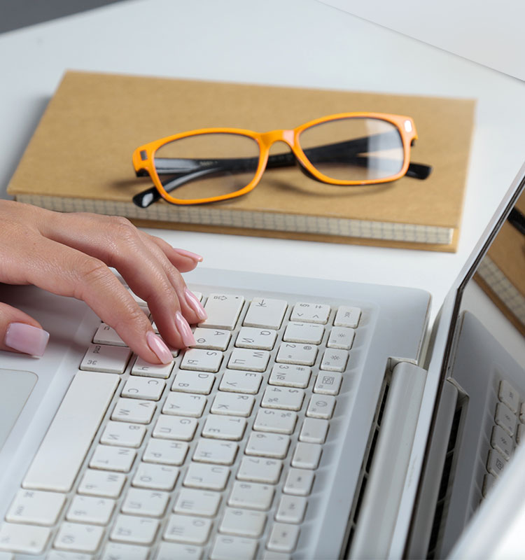 Bewerbungsformular Freelancer:innen; Hand auf Laptop-Tastatur