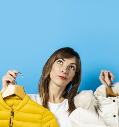 MTPE: Maßgeschneidert oder von der Stange; Bild einer Frau, die zwei verschiedene Winterjacken hochhält