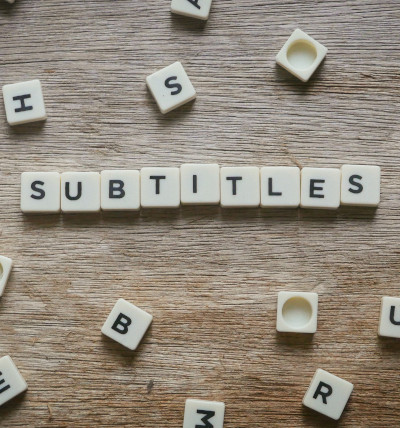 Videountertitelung mit oneSuite; Scrabblesteine, die das Wort Subtitles formen